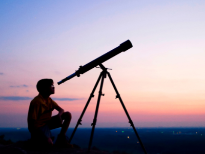 Child looking out of a telescope.